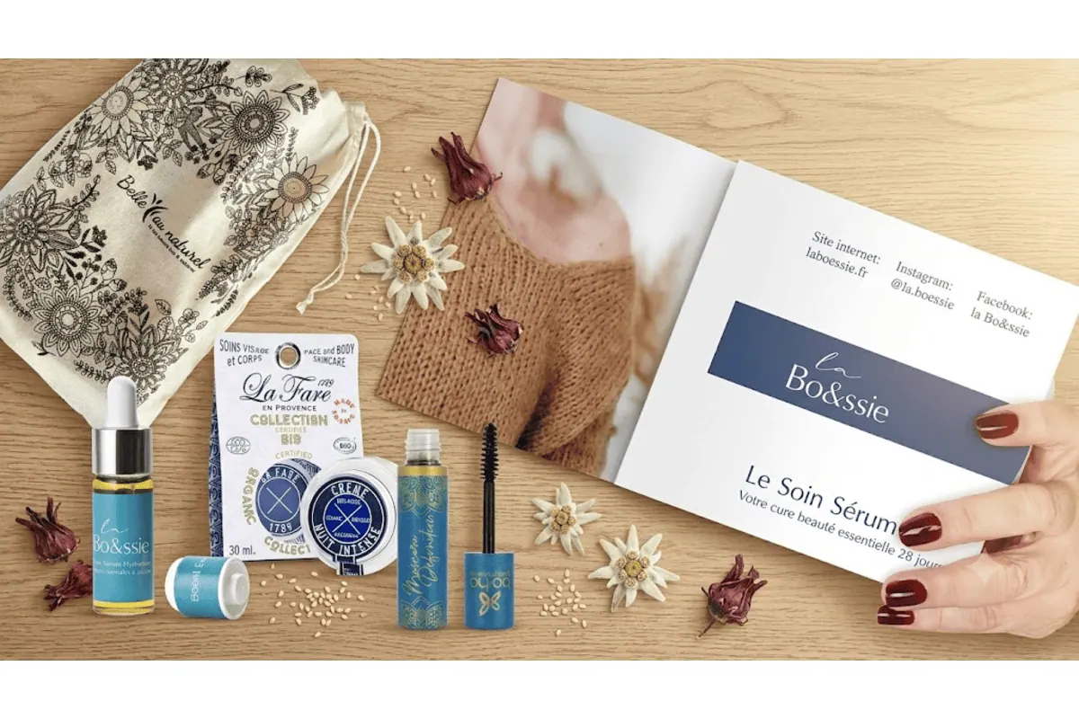 Belle au Naturel coffret Essentiels 40 ans présentation produits pochon coton bio sigle BAN sérum La Bo&ssie booster d'éclat pipette doseuse fioleverre Crème de Nuit La Fare en Provence pot verre fleurs séchées edelweiss livret soin sérum sur table bois clair